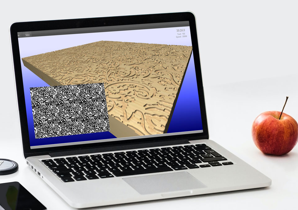 Egy laptop képernyőjén egy 3D CAD-es fa hasáb, aminek a felületén egy bonyolult, cizellált minta van marva.