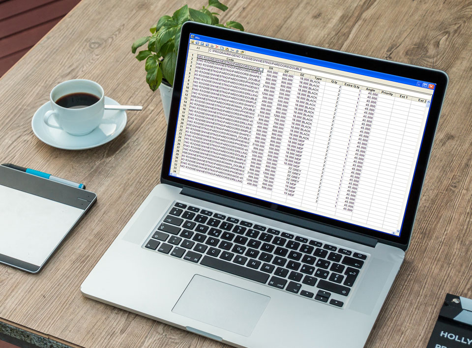Organikus környezetben egy fa asztalon kávé mellett egy laptop, aminek a kijelzőjén egy adattáblázat látható.